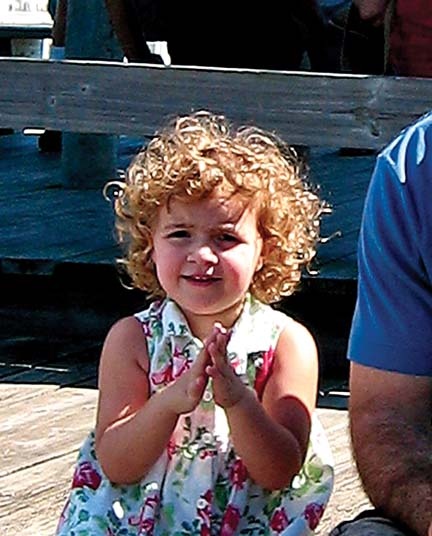 Although the overall shadow/highlight balance of this photo is about right, the detail in the face of this little concert-goer is obscured by backlighting and by her father's shadow. Careful dodging and burning can really improve these problems, as you can see in Figure 11-13.