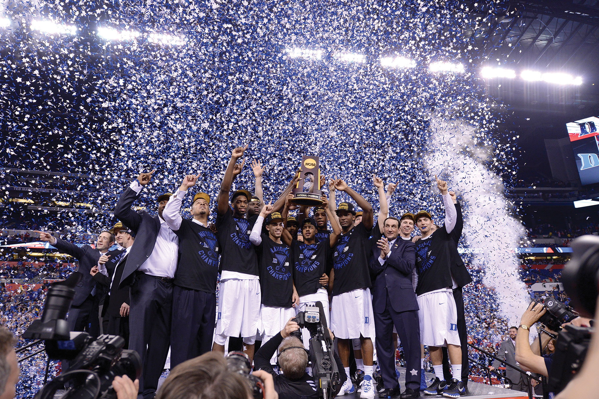 A photo shows a team celebrating their victory with the media and other people.