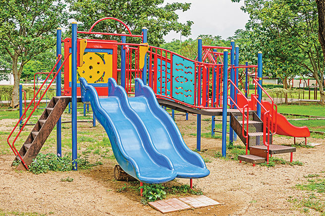 Photo shows multiple playground slides.