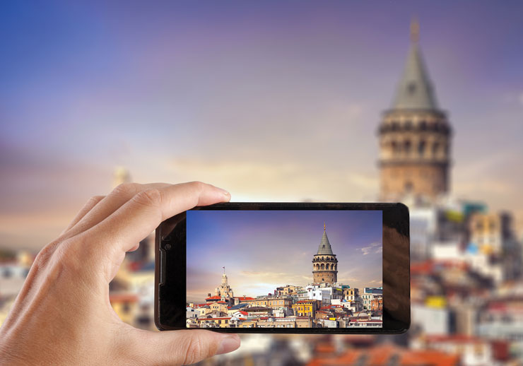 A photo shows someone taking a picture of Istanbul city in Turkey with a smartphone camera.