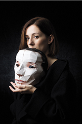 A photograph of Sara Lando holding a mask.