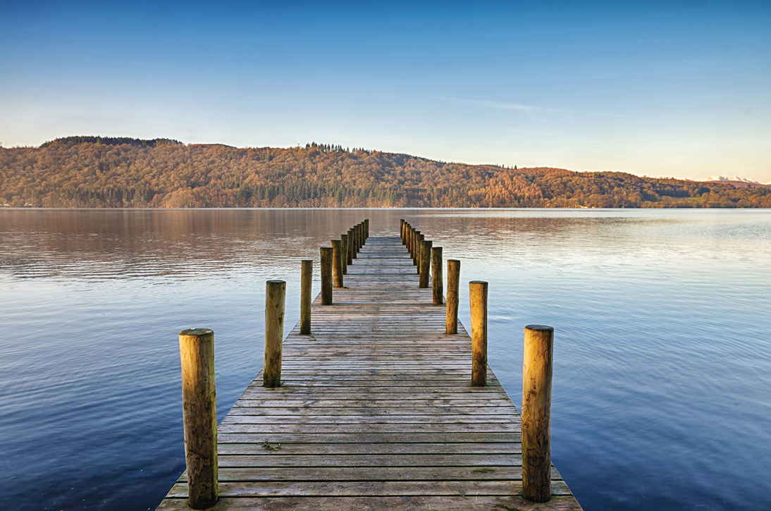 A photograph of a lake with a wooden jetty.