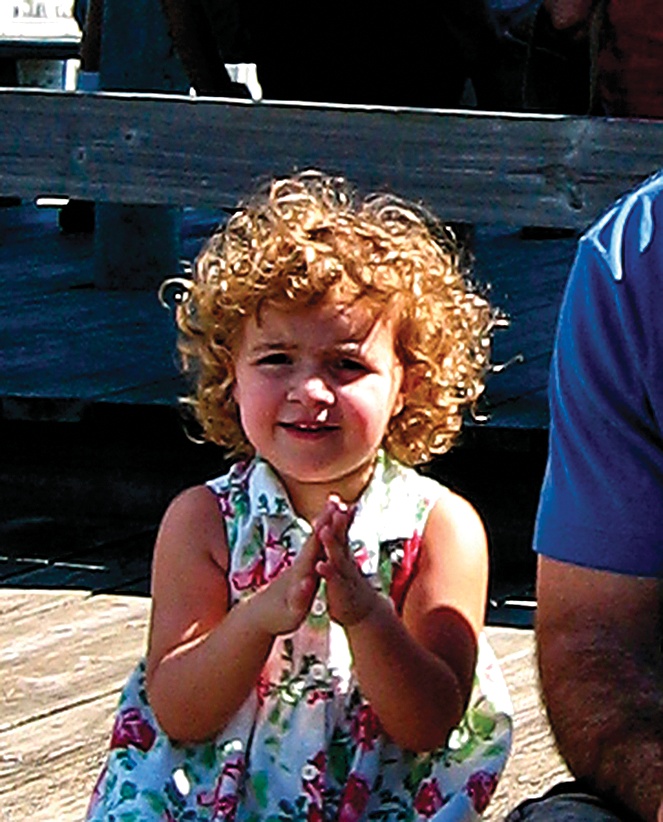 Although the overall shadow/highlight balance of this photo is about right, the detail in the face of this little concertgoer is obscured by backlighting and by her father's shadow. Careful dodging and burning can really help with these problems, as you can see in .