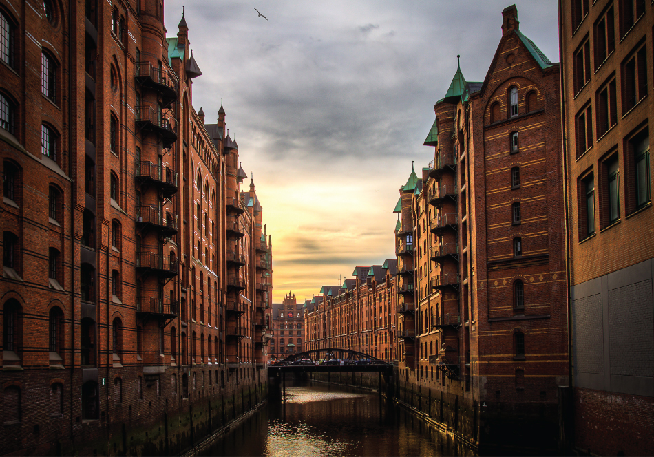 Photograph of a bridge over water. Buildings are seen on either side.