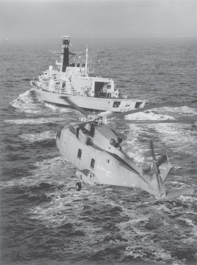 Photo of an EH101 Merlin approaching a Type 23 Frigate.