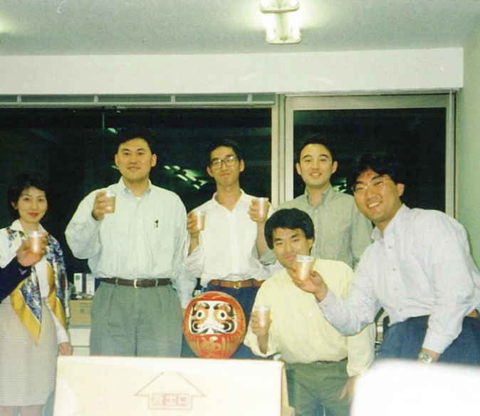 Photo illustration of a group of five men and one woman holding drinking glasses in their hands and facing the viewer.