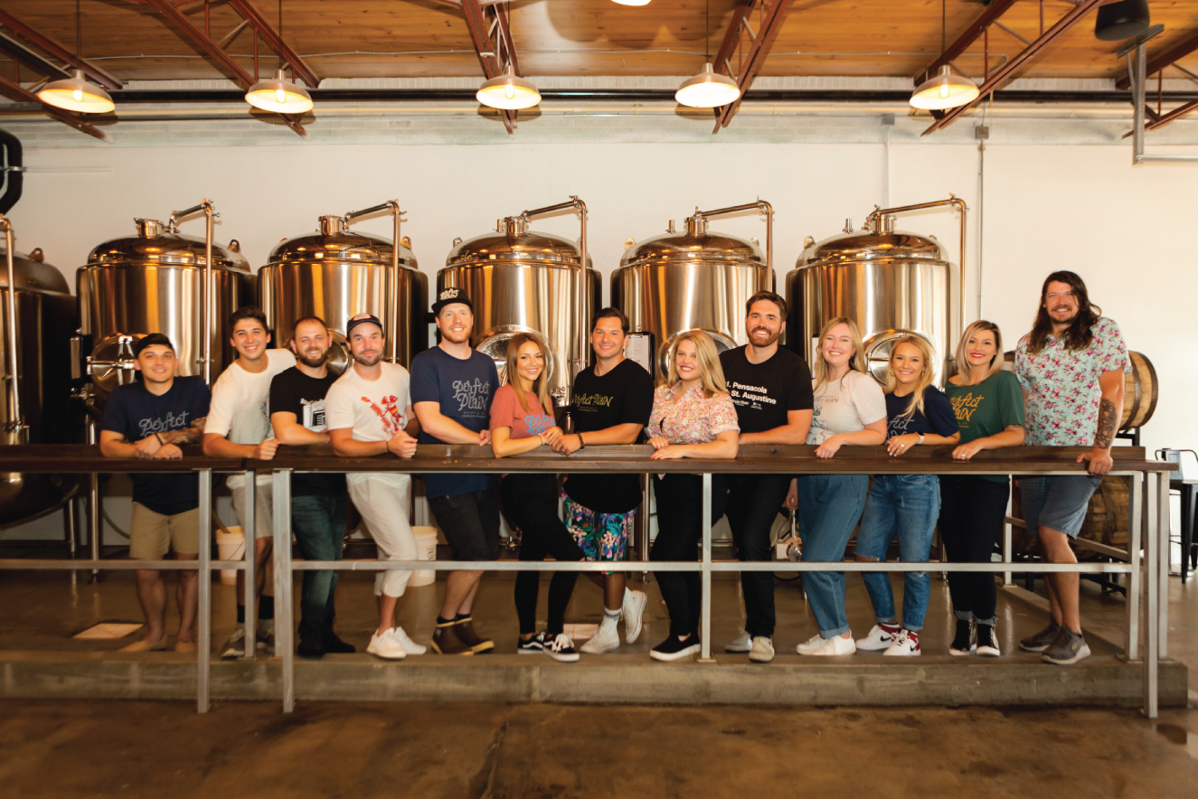 Photograph of a group of men and women employed in a brewing company.