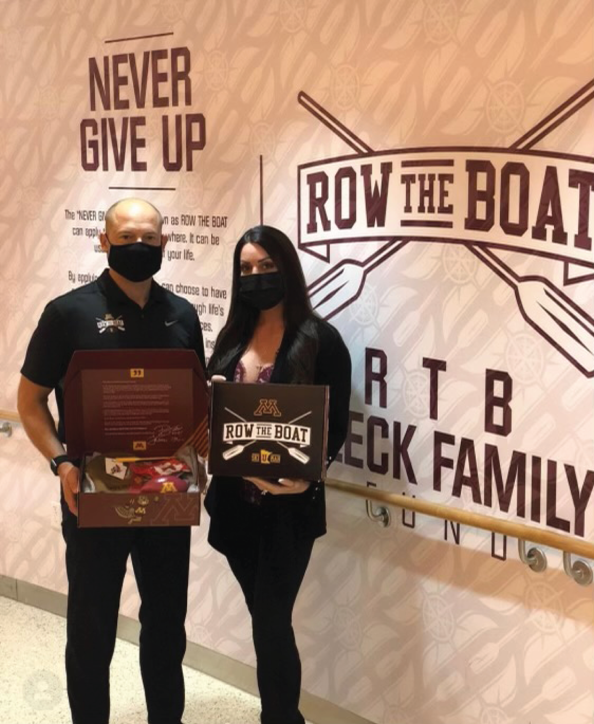 A photograph of a man and woman holding a shield from Row the boat.