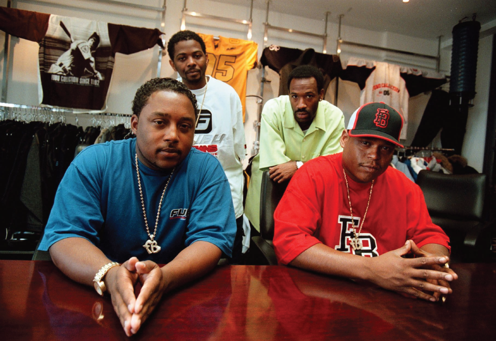 Photo depicts Daymond John (bottom left), Carl Brown, J. Alexander Martin, and Keith Perrin, the entrepreneurs behind FUBU, pose for a photo in their New York City offices in 1999.